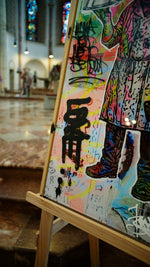 Detail Mr. Butcher: Josef Bathens Künstlerzeichen „5“, Tags und Signatur JBathen, Kirchenschiff im Hintergrund