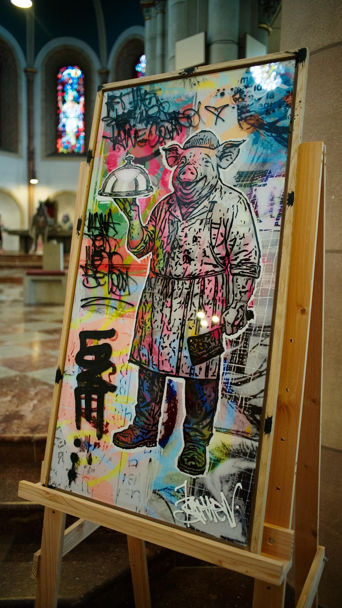 Mr. Butcher von Josef Bathen auf Holzstaffelei in einer Kirche: Schwein im Metzgerkittel mit Cloche, Mixed Media auf Acrylglas